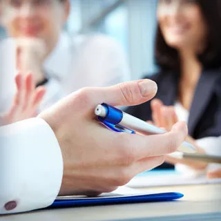 Doctor addressing patients with a pen in hand